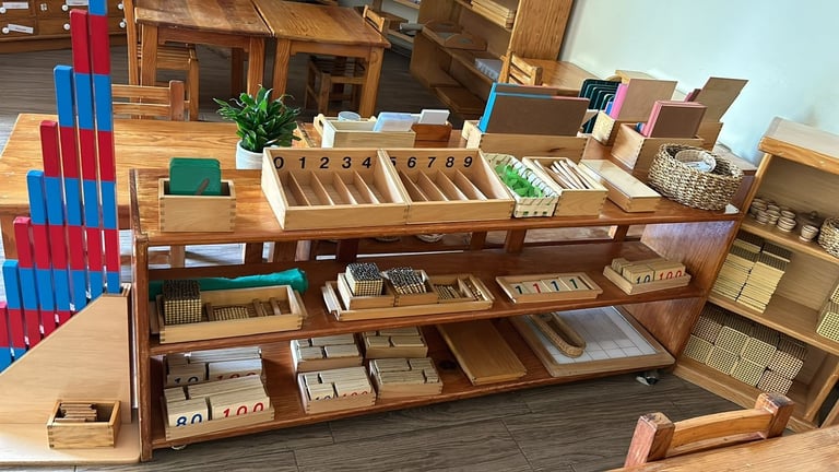 Wooden Montessori classroom shelving unit with organized educational materials, boxes, and learning supplies arranged by subject